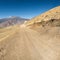 Dirt road through arid mountain wastelands.