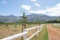 Dirt road through a farm with white picked fencing.