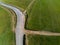 Dirt road intersecting the asphalt road drone view, simple catholic cross