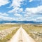 Dirt road leading trough dry rocky Mediterranean coastal lanscape of Pag island, Croatia in summertime