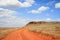 Dirt road orange prairie, going to the blue sky