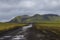 Dirt road after rain and moss-covered volcanic mountains. Landmannalaugar. Iceland