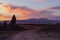 Dirt road running by tall pinnacle at sunset