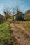 Dirt road on rural landscape with shabby shack