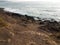 Dirt and rocks and hill and water at beach