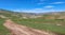 Dirt track leading up a Mongolian grassland valley on a summer day