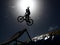 Dirtbike bmx rider jumps against sun