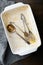 Dirty baking dish with used fork and spoon on wooden background