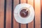 Dirty coffee cup and spoon setting on white saucer and wooden table after drinking in the morning. Soft focus