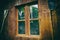 Dirty and dusty window on an old wooden barn, with working tools behind the glass. Close up of old window on aged cottage