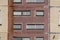 Dirty facade of a shabby prefabricated concrete house, lined with glossy ceramic tiles with decorative windows, close-up, textured