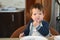 The dirty face of a young child with food. Babys face in white liquid. Close-up