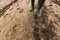 Dirty farmer`s rubber boots on muddy country road