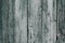 A dirty gray-green wooden surface. Grey wooden dilapidated boards. Wood plank texture background. Old wooden table, fence, timber,