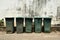 Dirty green bin and old cement wall