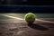 Dirty green tennis ball abandoned on dark tennis court