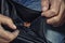 The dirty hands of a man holding an empty wallet with one coin. The concept of poverty.Poor man showing his empty wallet, closeup