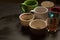 Dirty multi-colored cups, mugs, glasses after different types of coffee on a black wooden table left after morning