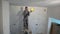 Dirty plasterer man polish ceiling with sanding grinder machine
