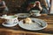 A dirty plate and an empty cup of coffee. The half-eaten cupcake on a plate. Empty dishes after eating on a wooden table