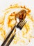 Dirty plate with fork and spoon on a light background. Spaghetti Bolognese leftover. Finished dinner