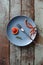 Dirty plate. Remains of homemade cake with blood oranges and small thuja branch on blue plate on shabby blue background copyspace