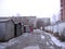 Dirty raw street go people pass between garages Novosibirsk