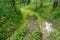 Dirty road with puddles in the forest. Impassable road in Russia