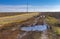 Dirty road between ripe sunflower fields in central Ukraine at late autumnal season