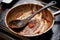 Dirty saucepan and spoon with remains of tomato souse, ready to be washed