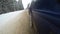 Dirty snow flies out from under the wheels of a car. slow-motion video view of the car`s side. driving on a car in a