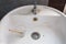 Dirty white washbasin, Clogged drain, Glass, Wooden spoon, Bathroom Cleaning concept