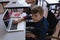 Disable schoolboy studying on laptop while sitting at desk in classroom