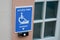 Disabled accessible arrow entry sign post with wheelchair handicap logo pmr means  people someone with reduced mobility on wall