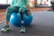 Disabled active senior woman exercising with dumbbell while sitting on exercise ball