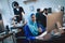 Disabled arab woman in wheelchair working in office. Woman is working on desktop computer and drinking coffee.