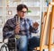 Disabled artist painting picture in studio