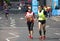 Disabled athlete running distance with guide runners in Canary Wharf. London