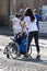 Disabled Athlete in a Sport Wheelchair during Marathon Helped by Female Runners