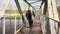 Disabled bearded senior man with walking stick moving slow and watching around on metal bridge