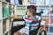 Disabled boy selecting a book from bookshelf in library