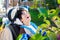 Disabled boy in wheelchair picking red apples off tree