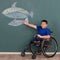 Disabled boy on wheelchair showing his painting on wall with happy and proud. Idea for learning ability of handicapped kid