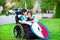 Disabled brother hugging older sister in wheelchair outdoors