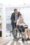 Disabled businesswoman discussing over digital tablet with businessman at office