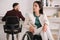 Disabled businesswoman looking away while sitting in wheelchair in office near colleague