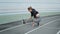 Disabled fit woman stretching legs on track. Lady preparing for workout outdoors