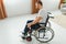 disabled man at home tries to get to his feet in a wheelchair. The concept of rehabilitation after injuries and car