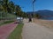 A disabled man in a wheelchair approaching the viewer. He is using the pedestrian pathway on the island of Ilhabela, Brazil, which