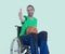 Disabled man in a wheelchair is doing sport with ball and thumb